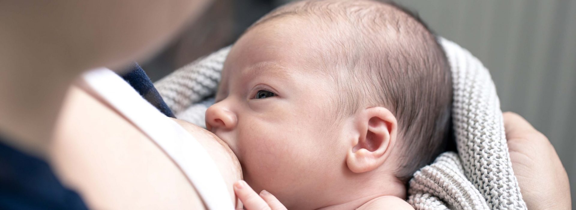 Mom breastfeeds her newborn son, breastfeeding, lactation in women, happy motherhood.